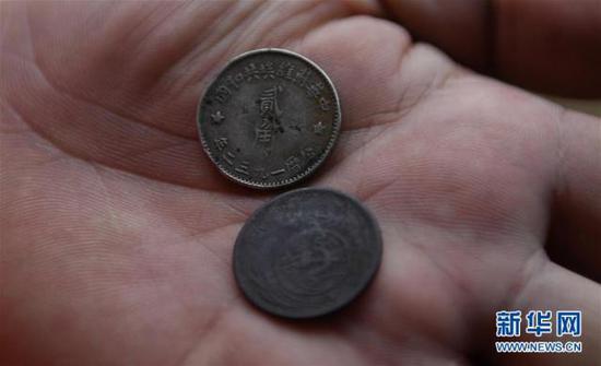 6月12日，罗小龙在展示中央苏区使用的货币。新华社记者 周密 摄