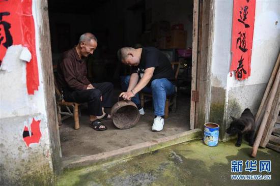 6月12日，罗小龙在一位老乡家收集文物。新华社记者 周密 摄