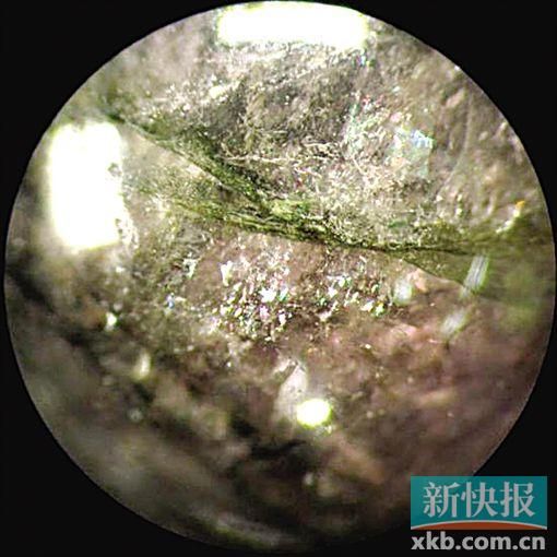 放大检查后,可见典型充填特征,裂隙或空洞,偶见气泡,沿裂隙可见“闪光效应”。