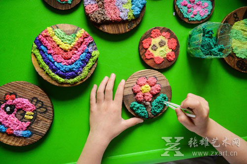 孩子们用染色后的废纸浆制作创意画