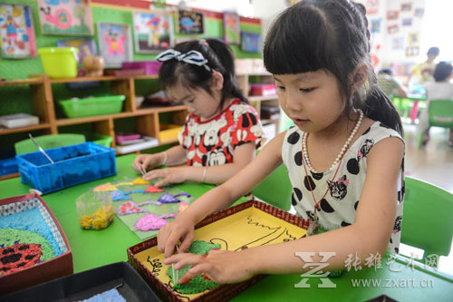 孩子们用染色后的废纸浆制作创意画