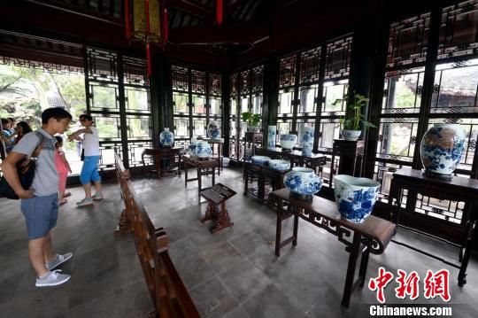 图为游客被展出的陶瓷艺术作品所吸引