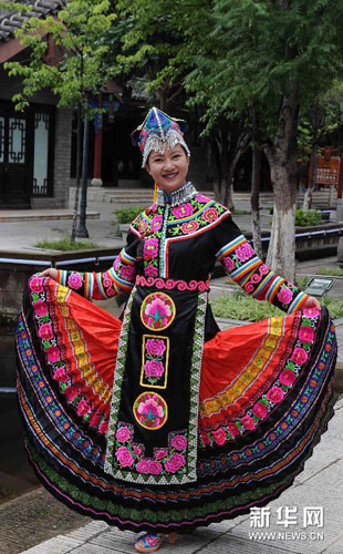 7月21日,楚雄彝族自治州永仁县的彝族绣女余芊亚在展示一款彝族手绣