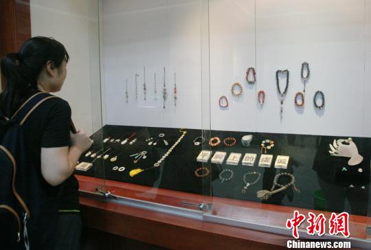   　近600件绚丽多彩、个性随意的珠串秒杀参观者的眼球。　邓霞　摄    　　