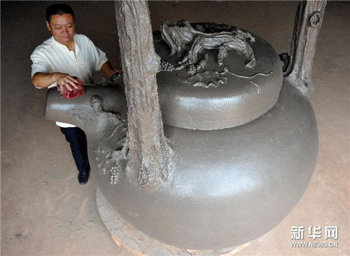 周占群在擦拭刚刚烧制出炉的巨型紫砂壶