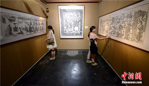 市民被展出的汉画像石艺术作品所吸引