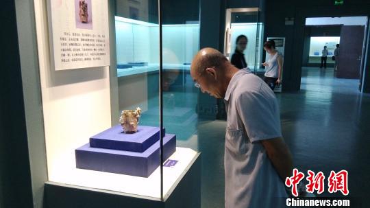 市民在欣赏青白玉朱雀踏虎衔环纹卮