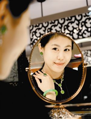  　　济南一家金店的工作人员在展示“珠圆玉润”翡翠饰品。据店家介绍，该套翡翠饰品包括项链、戒指、耳坠、手镯，质地为老坑玻璃种，总价约1300万元。 （新华社资料图片）