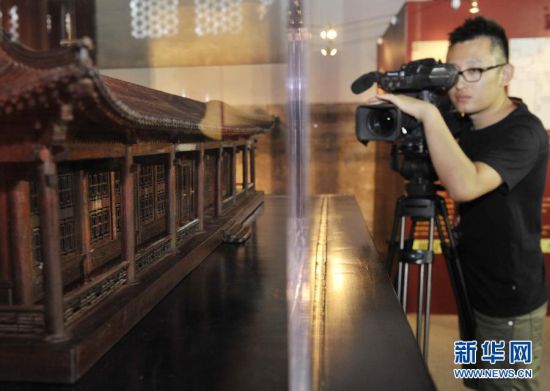一位记者在拍摄启动仪式上展出的澹泊宁静建筑模型。