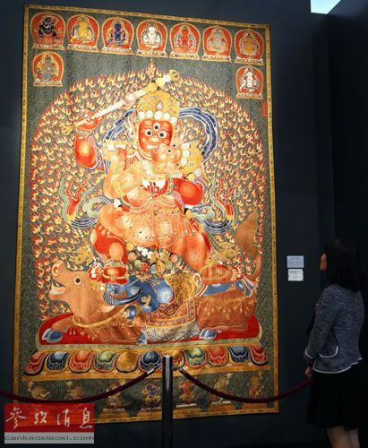   　　一位观众在香港佳士得2014年秋季拍卖会预展上观看明永乐御制红阎摩敌刺绣唐卡（11月21日摄）
