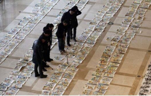        阅卷现场，一幅幅考试画卷铺满了大厅，评委老师手拿长棍在画面上指指点点，认真判卷。