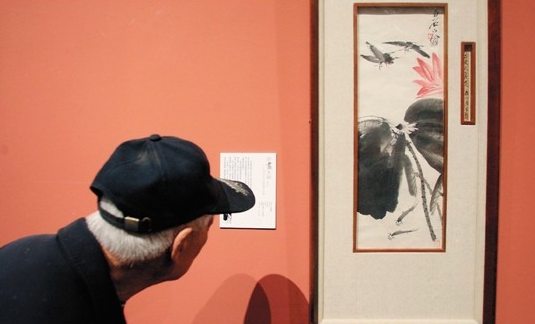 在石家庄举行的“中国近现代书画名家作品展”中，一位老人在观赏齐白石的绘画作品。(资料图片)