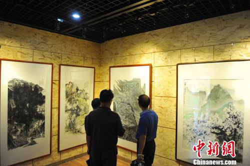 图为书画爱好者正在鉴赏即将拍卖的书画作品。