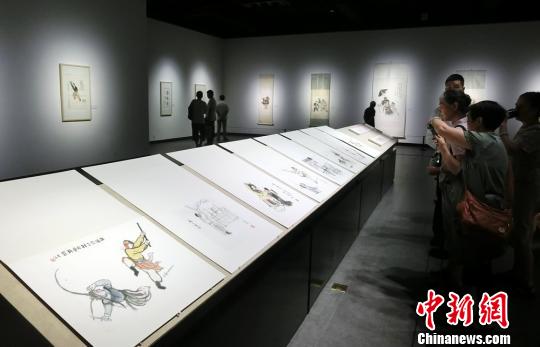参观者正在观摩关良画作 邓霞 参观者正在观摩关良画作 邓霞
