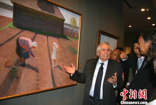   图为西德罗夫向参观者介绍他的成名作《在温暖的大地上》。　