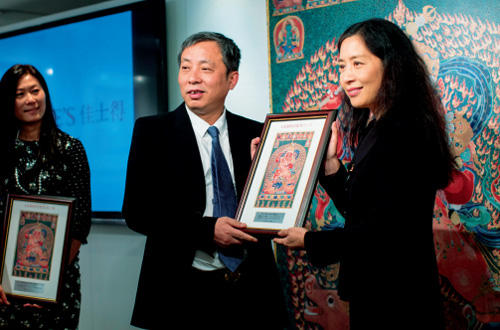 2015 年 3 月 12 日， 佳士得中国区总裁蔡金青 （右）向收藏家刘益谦交 付“明永乐御制红阎摩敌 刺绣唐卡”