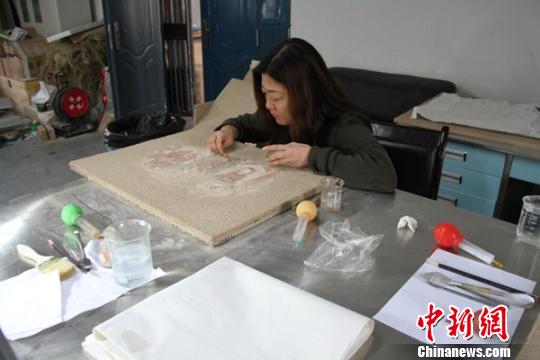 文物专家正在对壁画修复。