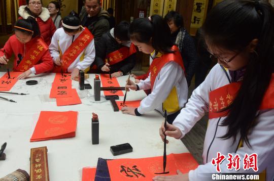  参与现场写春联活动的福州新店中心小学的十多位小学生书法爱好者，形成一道靓丽风景。　记者刘可耕　摄