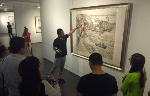  山东美术馆策展人张膑向参观者介绍画作。　胡健 摄