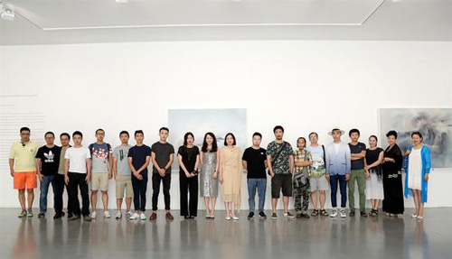图为展览开幕现场，参展艺术家合影