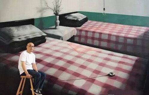   张晓刚在北京工作室，背后是他的作品《绿墙：两张单人床》(300x500cm， 2008)(图片来自Wmagazine)