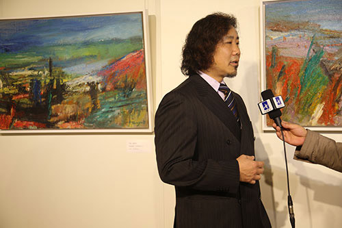     图为著名画家唐承华在活动现场接受记者采访。