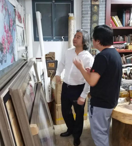   ▲王来文在胡育光画室指导画展作品