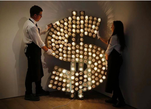 苏富比员工为一幅由Tim Noble和Sue Webster创作的《$》调整位置。图片：Adrian Dennis/AFP/Getty Images