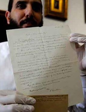 图为2018年3月6日拍摄的资料图片，显示了 Winner 拍行所有者兼经理加勒•维纳 (Gal Wiener) 展示由诺贝尔物理学奖得主爱因斯坦于 1928 年书写的签名信函。图片来源：法新社/梅纳赫姆•卡哈那。